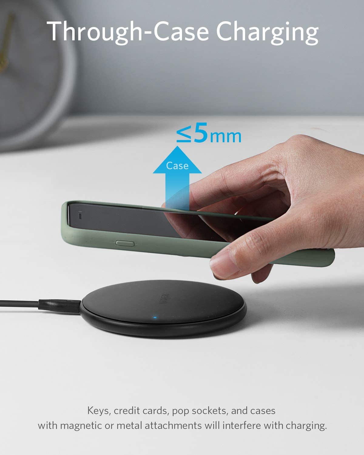 Hand placing a smartphone on a wireless charging pad with text about through-case charging.